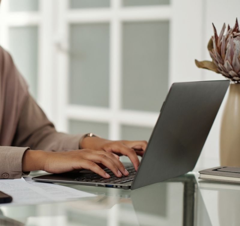 womans hands on laptop